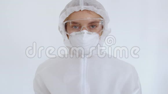 一个戴防护眼镜面罩和化学防护的女孩的肖像显示她的手有一个十字架一个女人视频的预览图