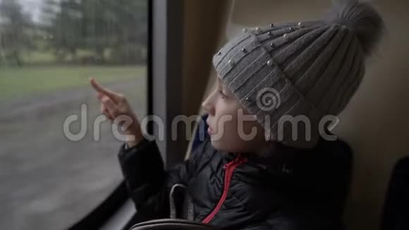 一个小女孩坐在公共汽车的后座上呼吸着公共汽车的车窗吸着玻璃视频的预览图