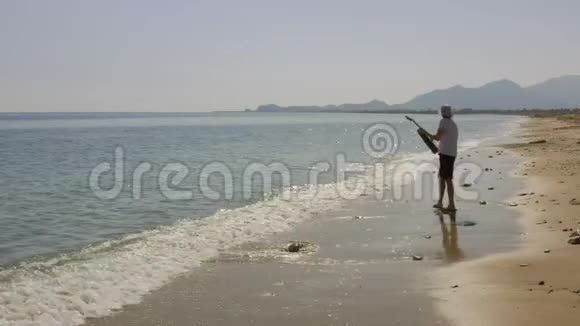 人在海里或海里扔吉他吉他手在水里扔乐器吉他漂浮游泳漂流旋转视频的预览图