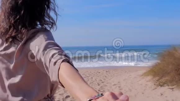 女人牵着一个男人的手去海滩视频的预览图