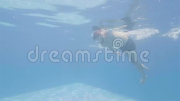 戴护目镜的人正在游泳在游泳池里爬行侧视视频的预览图