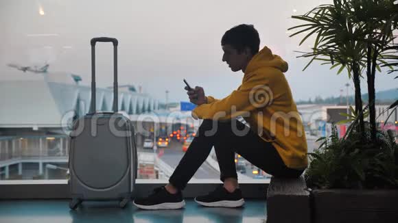 青年游客带行李在机场候机楼等候的剪影旅客使用视频的预览图