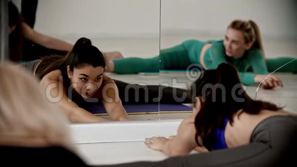 一群妇女坐在镜子前的腿上向前弯曲视频的预览图