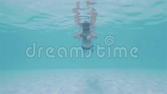 年轻人在水下游泳和在游泳池里看相机的肖像视频的预览图