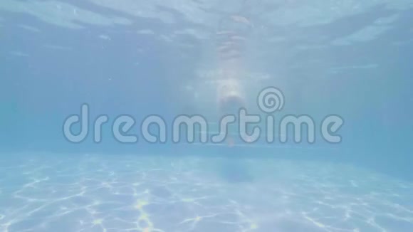 戴着面具的成年男子在蓝水漂浮的游泳池下游泳并向流浪汉展示一位微笑的开朗的人视频的预览图