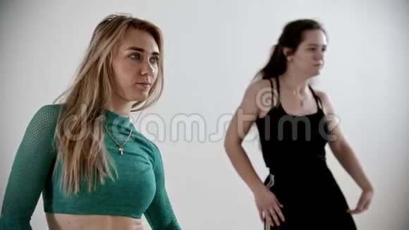 两个运动的女人在白色工作室的健身训练中热身视频的预览图