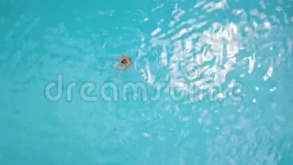 在度假酒店的蓝色游泳池里游泳的无人视野男子空中观景男子游泳运动员夏季在室外游泳池游泳视频的预览图