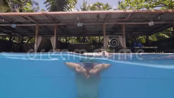 男子游泳从游泳池在度假酒店的水线景观戴护目镜的帅哥从户外出现视频的预览图