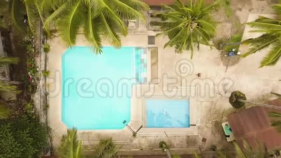 热带度假酒店的无人机景游泳池年轻人在蓝水游泳池游泳暑假在视频的预览图