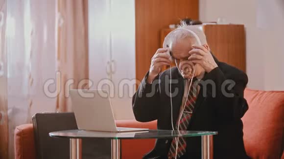 一位年迈的祖父正戴着耳机伴着音乐跳舞视频的预览图