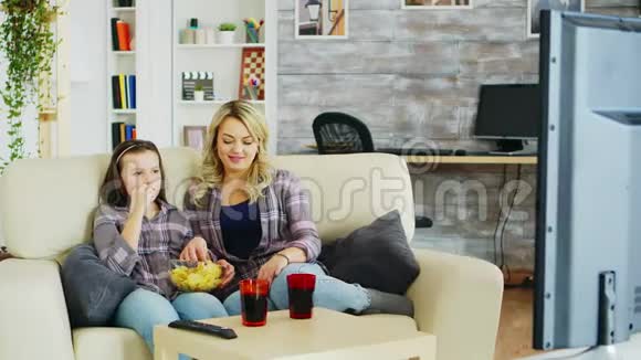 带着牙套的小女孩和妈妈坐在沙发上视频的预览图