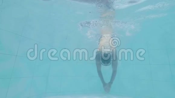 男子游泳运动员潜水在游泳池的热带棕榈背景戴护目镜的年轻人在度假泳池游泳视频的预览图