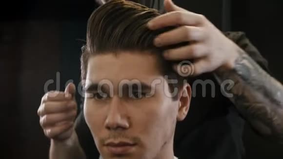 戴黑色面具的理发师用凝胶给客户头发做造型视频的预览图