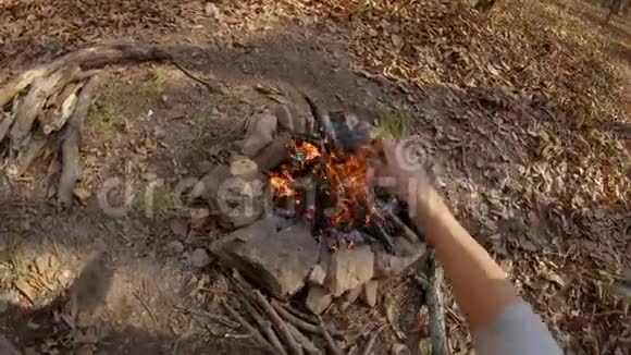 秋天森林中一个人坐在篝火旁的镜头视频的预览图
