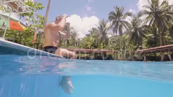 人在游泳池潜水在热带岛屿的室外自由泳视频的预览图
