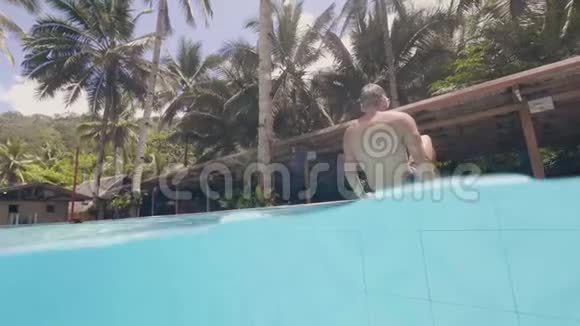 在避暑胜地的泳池边一个性格开朗的人倒在水池里快乐的人在游泳池度过快乐的暑假视频的预览图
