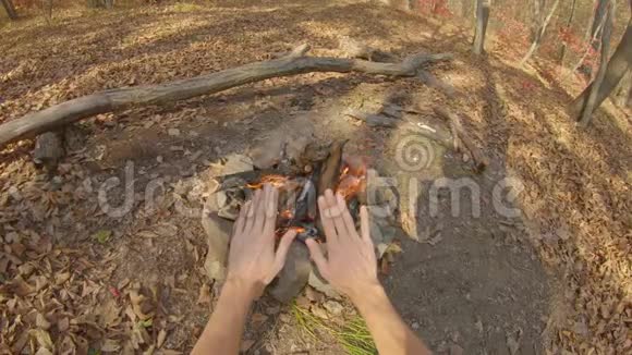 视角拍摄一个人坐在秋林篝火旁慢镜头视频的预览图