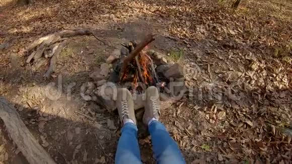 秋天森林中一个人坐在篝火旁的镜头视频的预览图