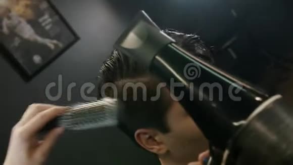 理发师用吹风机和刷子给客户在太阳穴上的头发做造型视频的预览图