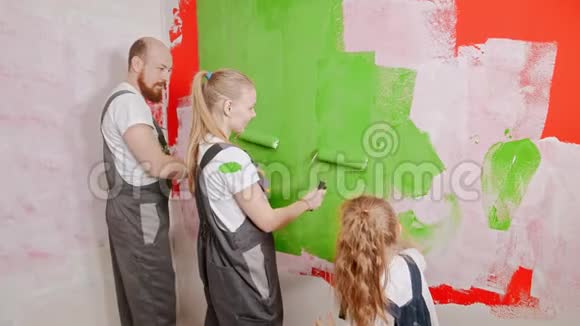 妈妈和爸爸在玩颜料而女儿在画墙视频的预览图