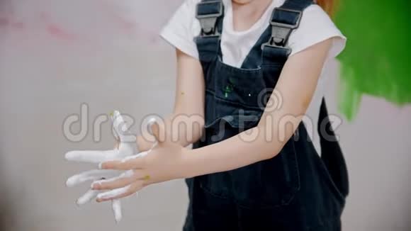 小女孩用白色油漆检查她的手视频的预览图