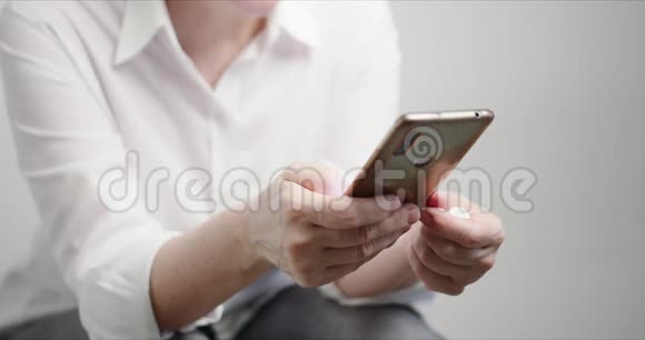 中年成熟的女人手里拿着智能手机看着屏幕视频的预览图