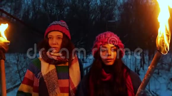 两个年轻的女朋友晚上站在桥上手里拿着燃烧的火把望着前方视频的预览图