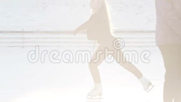 一个年轻的金发女人在阳光明媚的溜冰场上滑冰视频的预览图