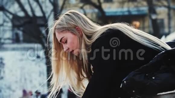 一个年轻的金发女人在走在溜冰场前把她的溜冰鞋绑起来视频的预览图