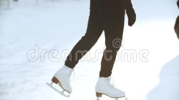 一个年轻漂亮的金发女人在溜冰场上的职业花样滑冰运动员在自己周围旋转视频的预览图