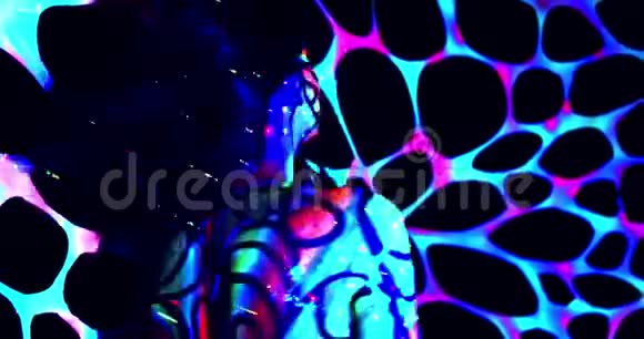 一个女人和背景紫外线舞蹈4k的彩色和明亮的身体艺术视频的预览图