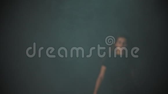 一个年轻漂亮的女人长发从工作室的烟雾中走出来站在姿势上视频的预览图