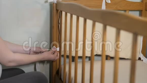 年轻漂亮的孕妇在婴儿到来之前在婴儿房里组装婴儿床视频的预览图