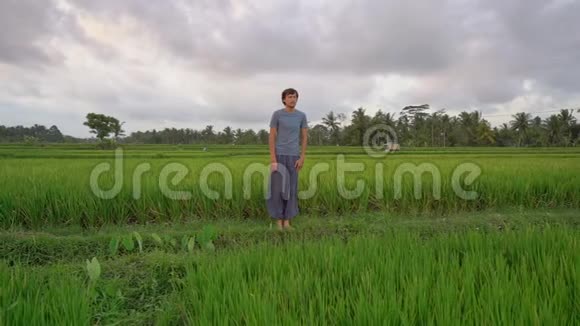 一个年轻人在一个美丽的稻田上进行瑜伽训练旅游亚洲概念慢速视频视频的预览图