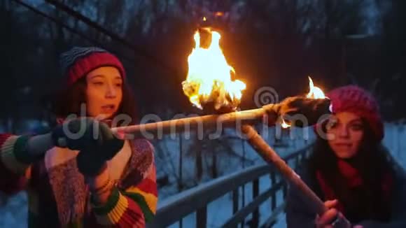 两名年轻女子在冬天的森林里用火把打架视频的预览图