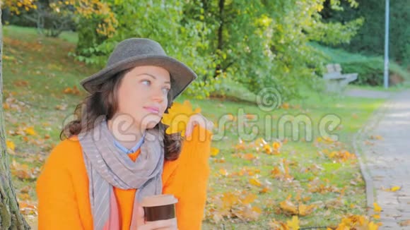 女人在秋天的花园里喝咖啡享受秋天的阳光视频的预览图