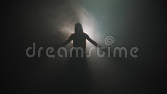 一个年轻迷人的女人在明亮灯光的背景下跳舞的剪影视频的预览图