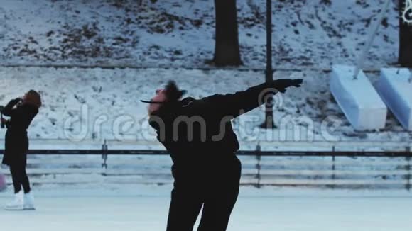 一个年轻的金发女人在户外的冰场上溜达视频的预览图