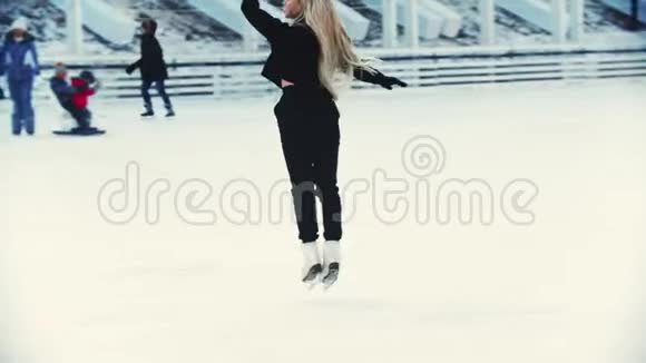 一位年轻的金发女子职业花样滑冰运动员在户外溜冰场滑冰视频的预览图