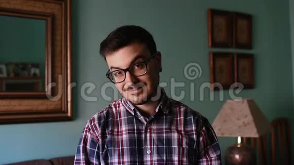 一个年轻人在家的肖像他在笑视频的预览图