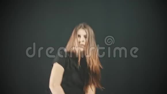 一个年轻性感的女人在黑暗的烟雾工作室跳舞视频的预览图
