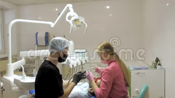 女牙医助理做男性病人在牙科中清洁牙齿视频的预览图