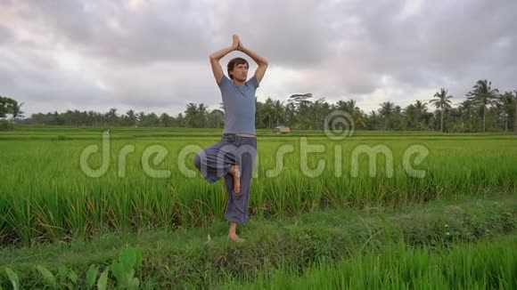 一个年轻人在一个美丽的稻田上进行瑜伽训练旅游亚洲概念慢动作视频视频的预览图