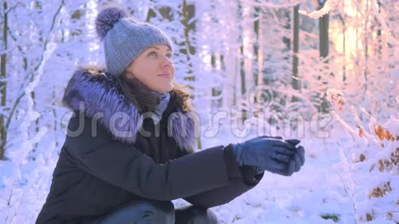 白雪森林中年轻迷人女子的冬季画像视频的预览图