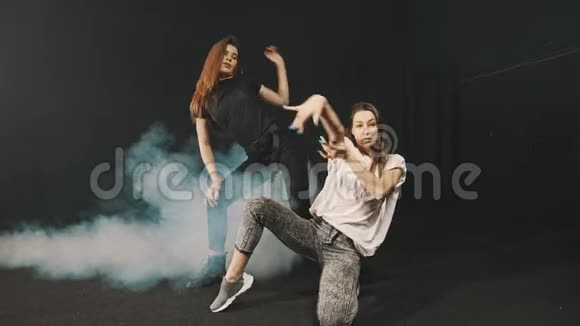 两个年轻女子在烟雾弥漫的工作室里训练她们的舞蹈风格视频的预览图