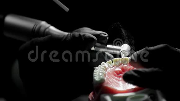 牙科医生戴着黑色手套用钻床完成牙齿骨架的模拟牙医很灵巧视频的预览图