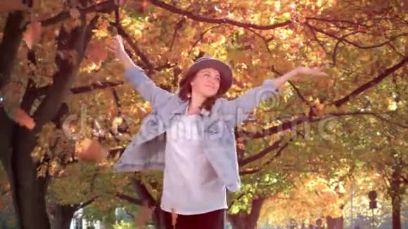 公园里快乐的美女秋天的落叶视频的预览图