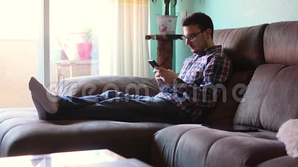 年轻人在家里发短信看手机视频的预览图