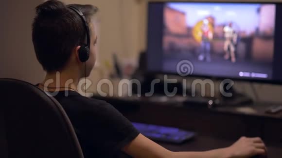 青少年男孩在桌面电脑上玩在线射击游戏视频的预览图