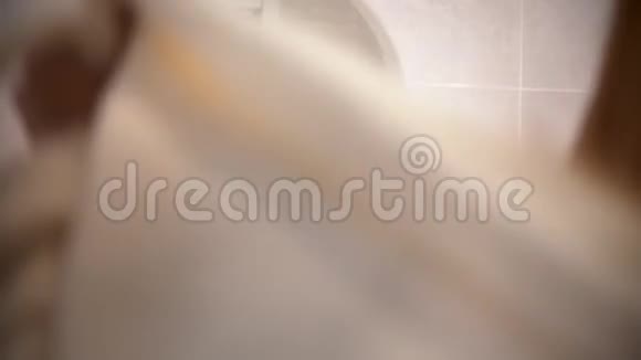 一位年轻女子穿着浴袍手里拿着发刷跳舞唱歌走在浴室里视频的预览图
